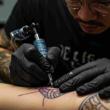 타투이스트가 숙련된 손길로 고객의 피부에 문신을 새기는 섬세한 작업 과정이 담겨 있다. (AI 생성 이미지)